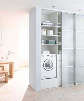 laundry room in cupboard with sliding doors