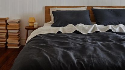 Dark colored bedding styled on bed 