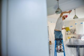 a man painting a ceiling