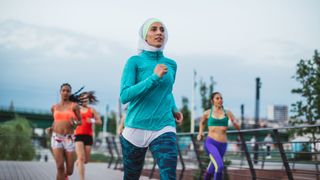 Woman running marathon with others