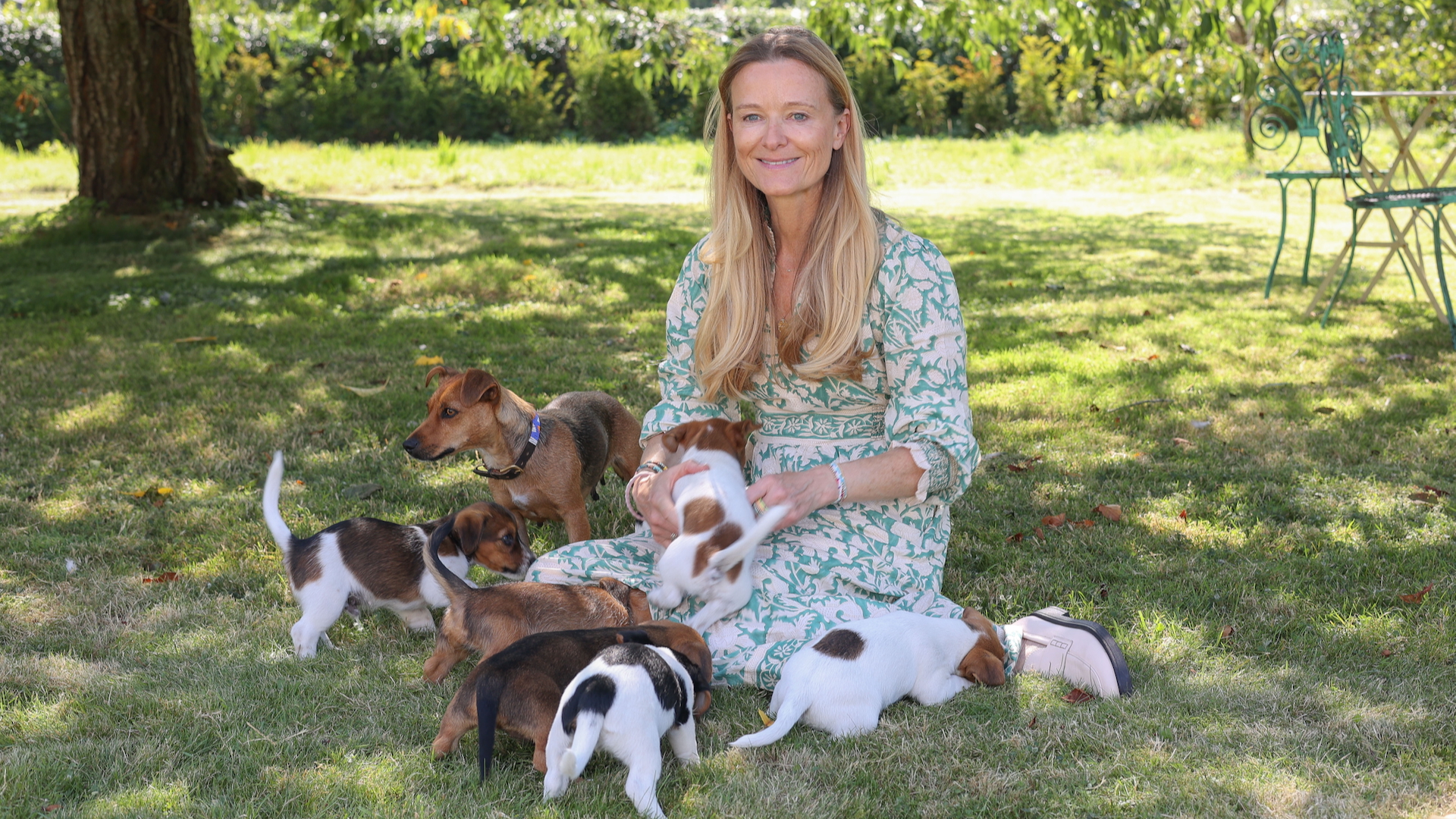 Lucy Macnamara, who has ADHD, plays with a litter of puppies in a garden