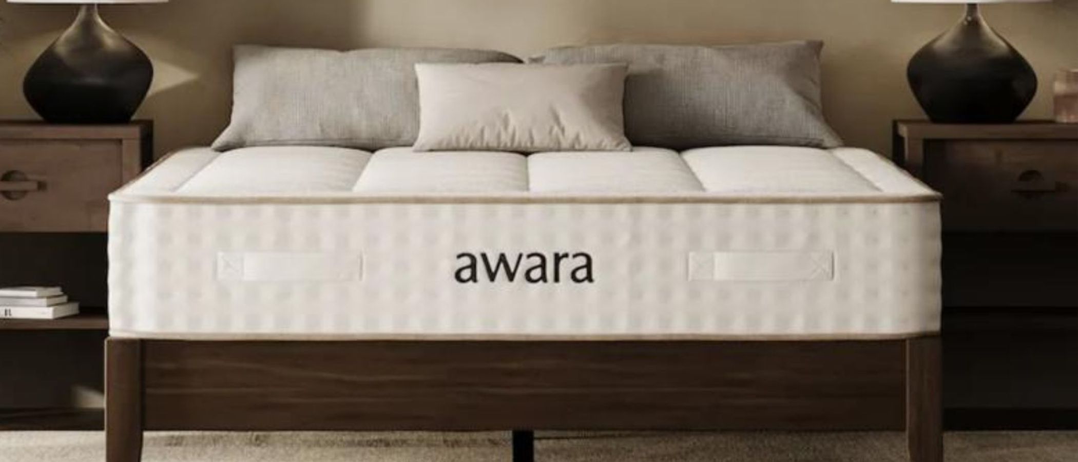 The image shows a deep beige mattress on a dark brown wooden bed frame, placed in a neutrally decorated bedroom.