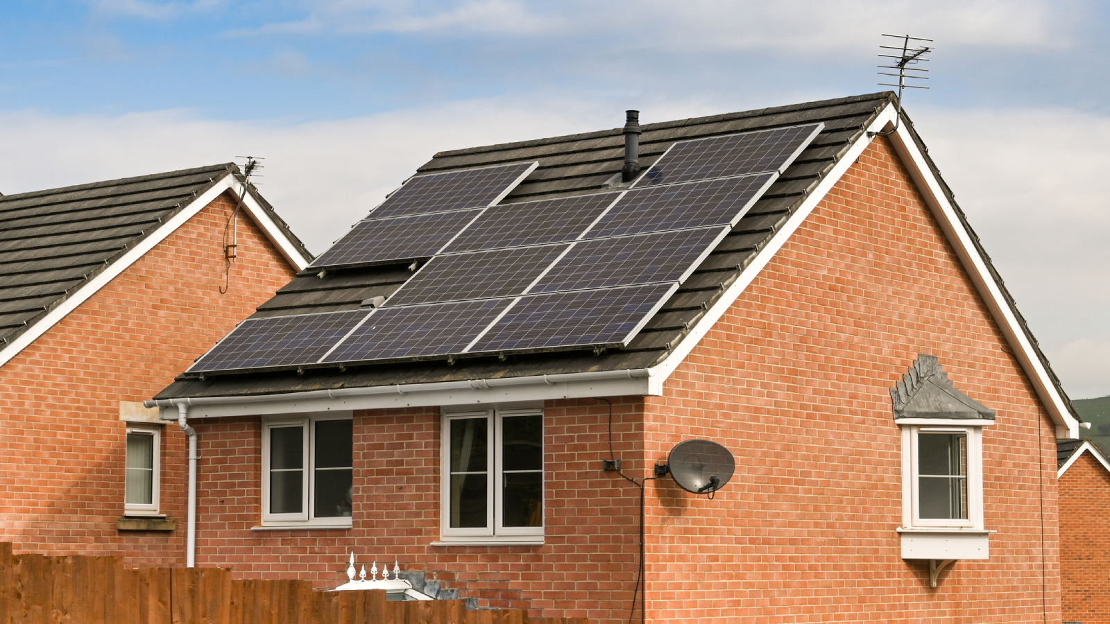 detached brick house with solar panels on roof