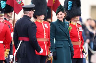 Kate Middleton wearing a green coat smiling and looking at soldiers on St Patrick's Day 2025