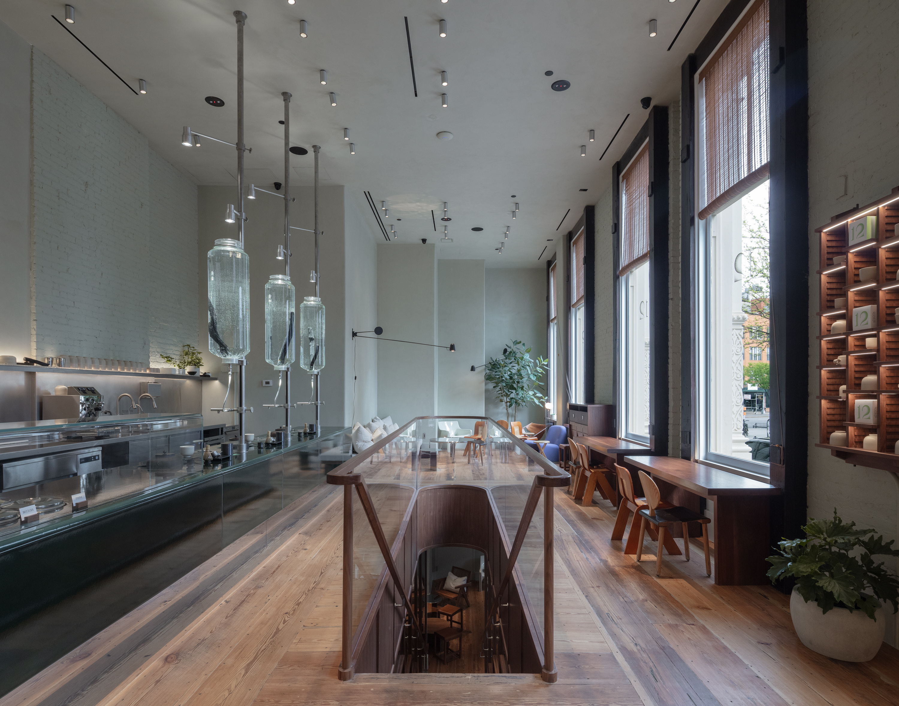 A futuristic matcha cafe features Japandi interiors punctuated by wood, chrome, or emerald green tones, and a sci-fi-esque bar setup with dripping water bottles and lights.