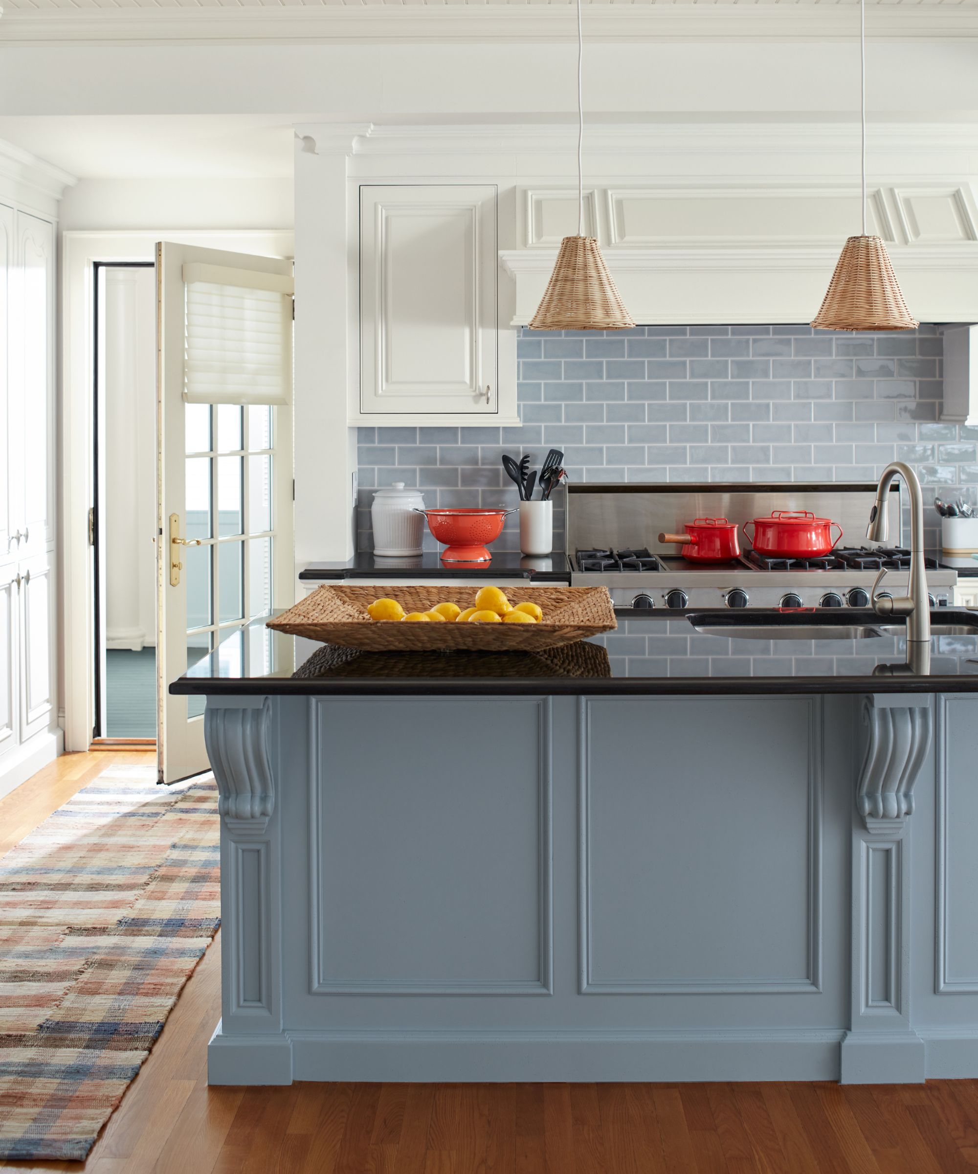 A gray and white kitchen with rattan accessories