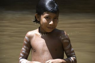 A tribal girl of the Awa people in a stream.