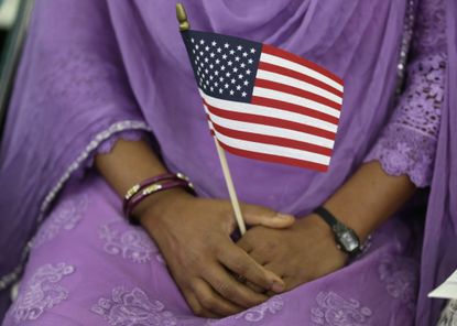 A new U.S. citizen holds an American flag at a naturalization ceremony.