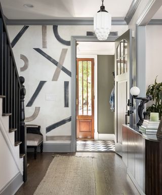 entryway with wood floor, line pattern paintwork on far wall and blue-gray trim