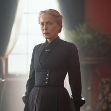 gillian anderson wearing a black dress and standing in a parlor as constance van ness in the abandons