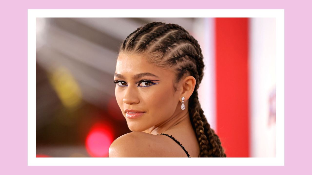 Zendaya wears her hair in braids and wears purple eyeliner as she attends Sony Pictures&#039; &quot;Spider-Man: No Way Home&quot; Los Angeles Premiere on December 13, 2021 in Los Angeles, California. In a pink template