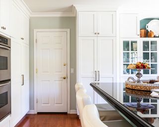 A traditional kitchen with white cabinetry and breakfast bar