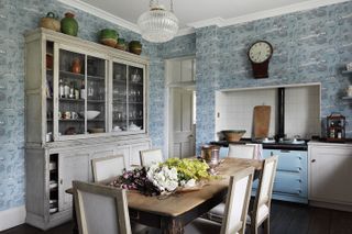 Antique furniture and a glamorous pendant light add character to a country house kitchen