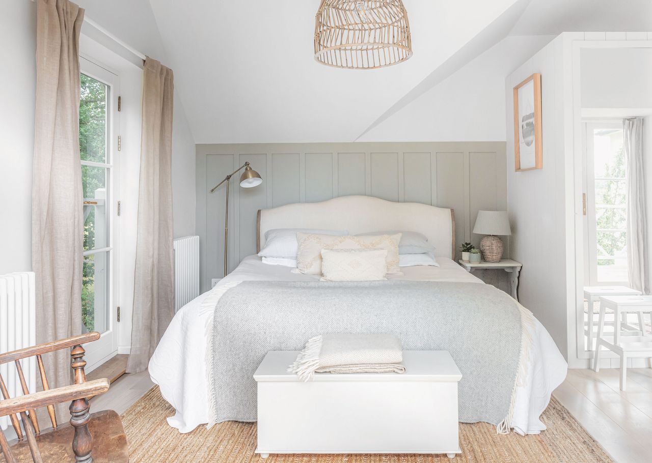 main bedroom with neutral furnishings and panelling behind bedhead