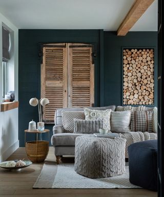 A dark teal cozy living room idea with gray soft furnishings and natural wood textures.