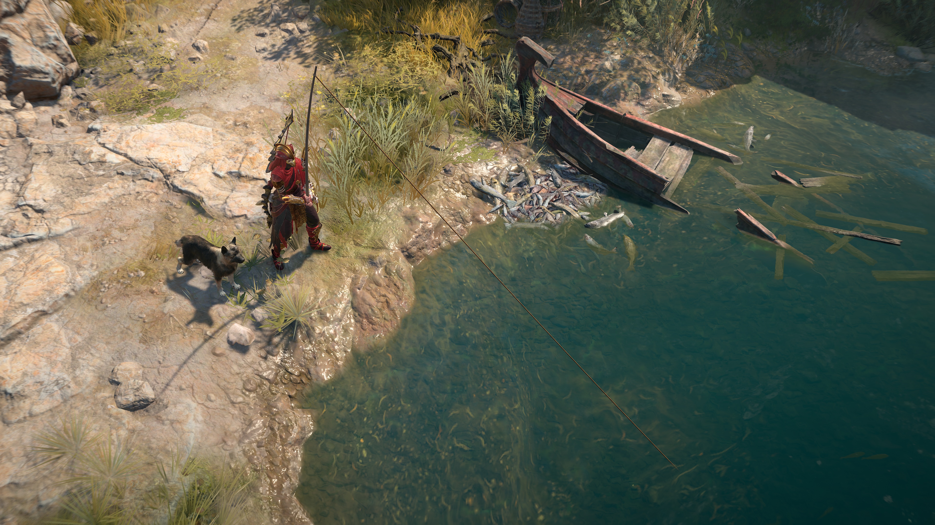 A person in red armor stands by a riverbank with a black dog, near a sunken boat. The clear water reveals underwater debris
