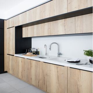 wooden kitchen cabinets with white countertops and stainless steel sink