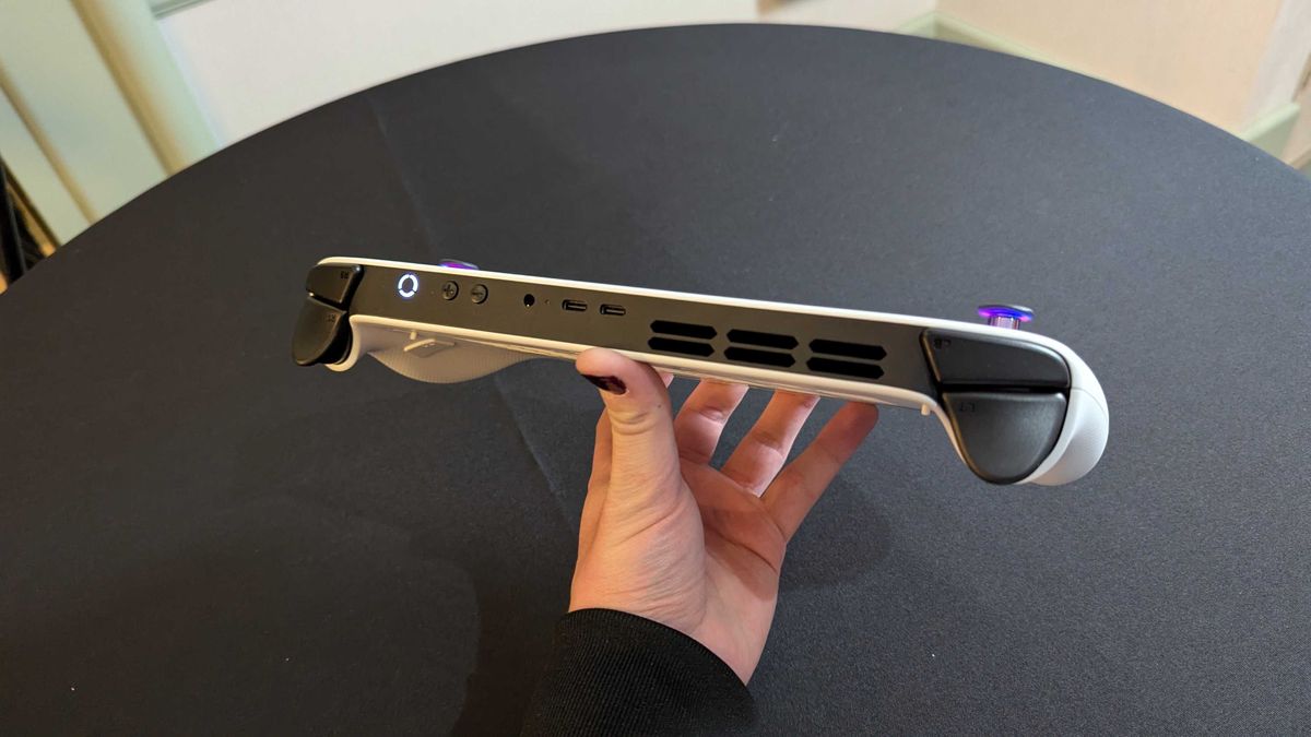 A Lenovo Legion Go S with Windows held in the hand and seen from the top, showing its buttons, 3.5mm audio jack, dual USB Type-C 4.0 ports, and top ventilation.