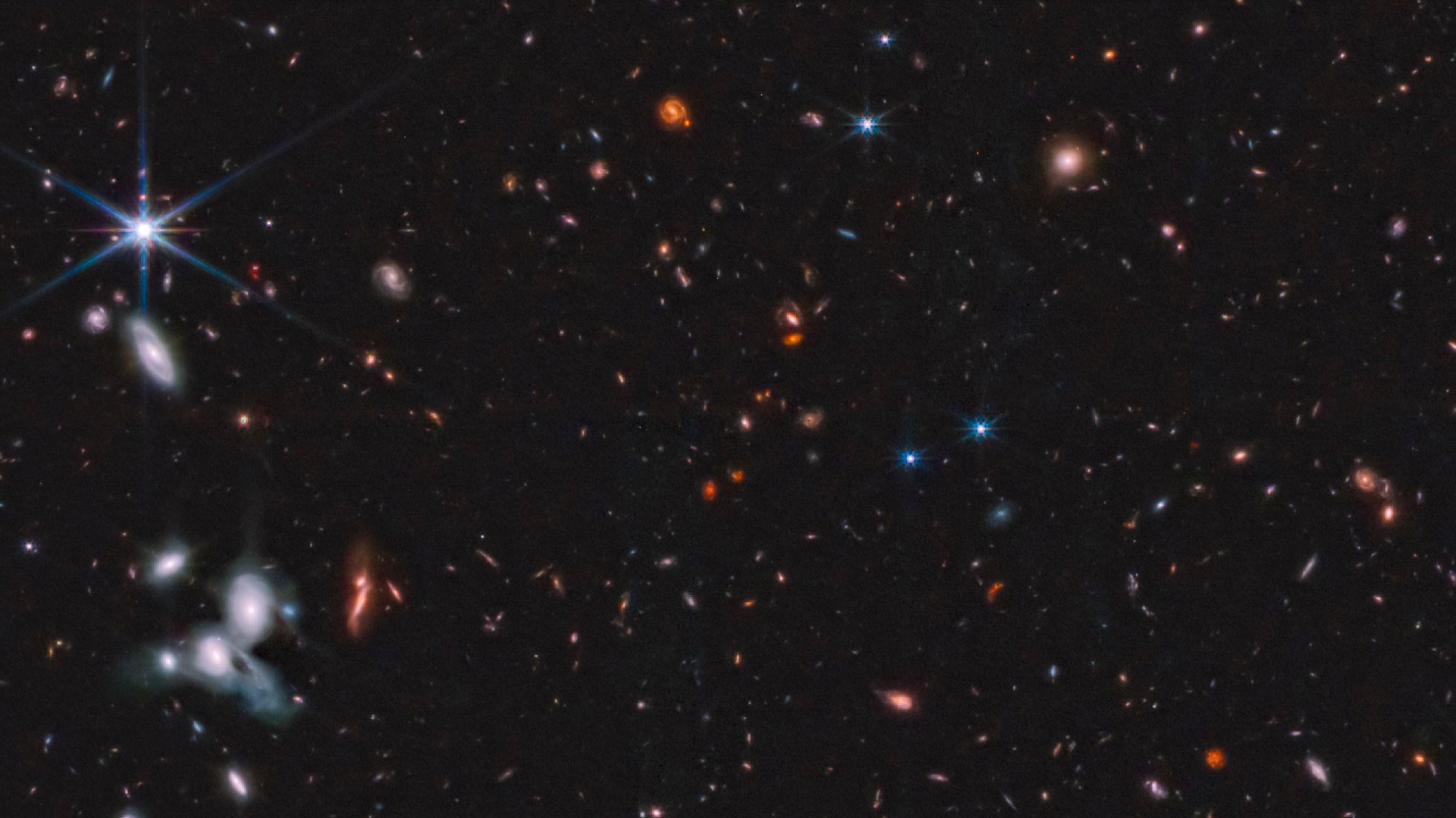 A section of the Epoch 1 mosaic, with a pair of interacting spiral galaxies visible in the bottom left corner, also with a white spot indicating possibly the first supernova captured by JWST.