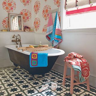 bathroom with white bathtub wallpaper and towel