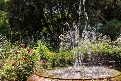 A garden with a round water fountain