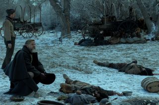 joe tippett leans over dead bodies in a snowy scape in a scene from american primeval