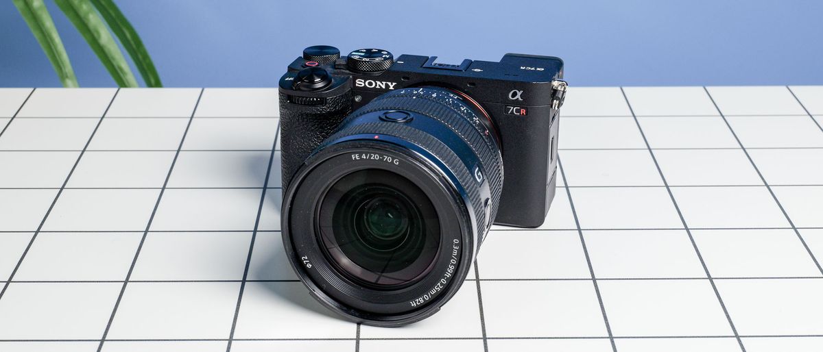 The Sony A7CR on a white table with a blue wall in the background