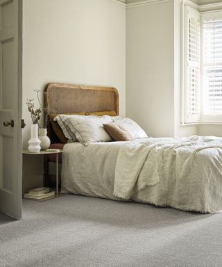 Bedroom carpet ideas with textured grey carpet with rustic grey linens on the bed