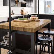 Black kitchen stools around wooden kitchen island countertops in small space