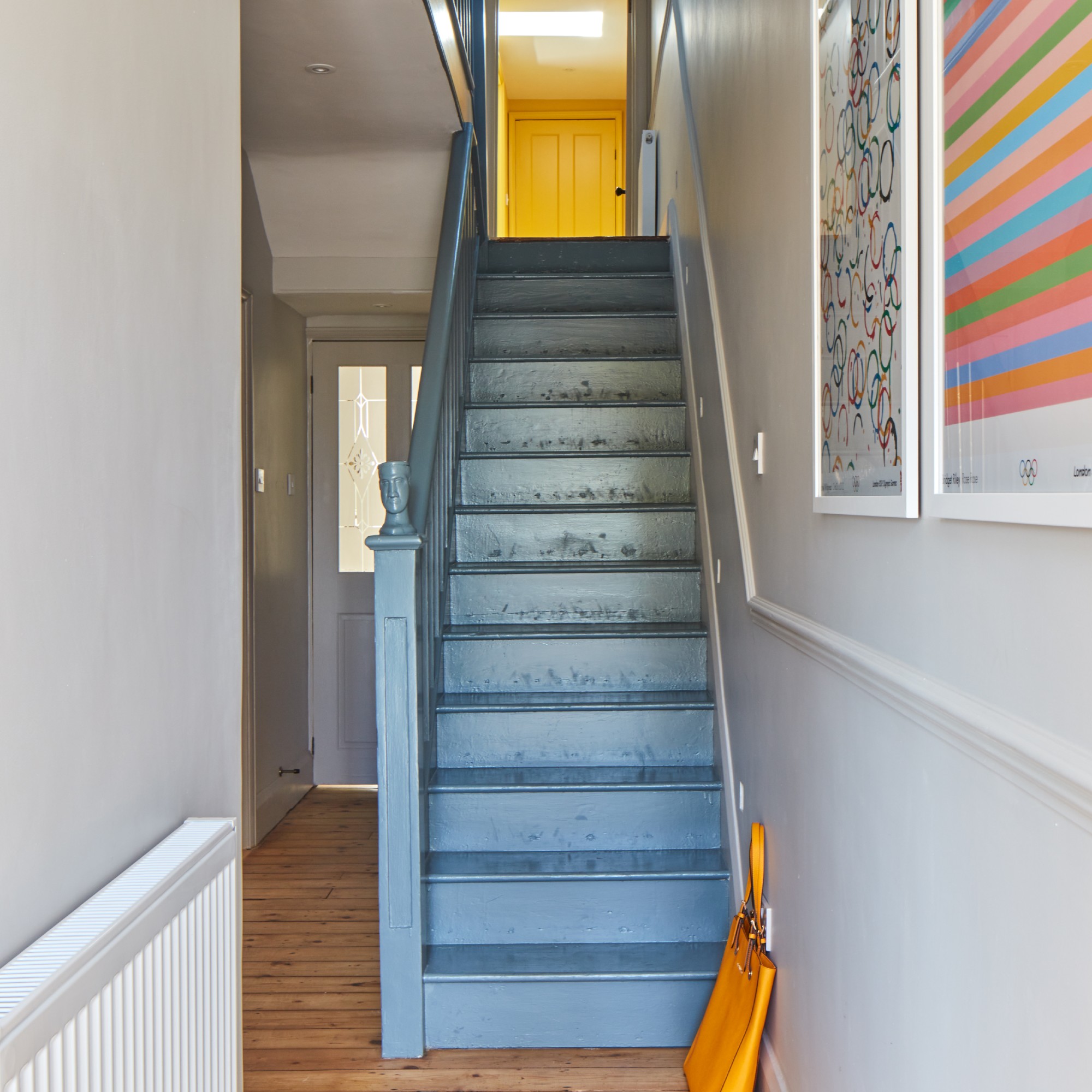 A neutral hallway with a contrasting blue staircase