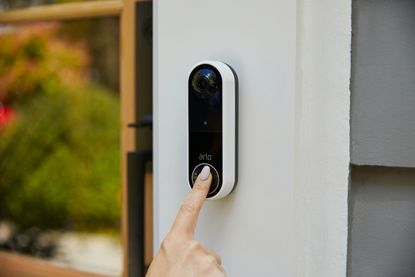 Woman using the Arlo Essential Video Doorbell Wire-Free model