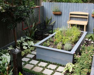 A small backyard with a raised garden bed in the center