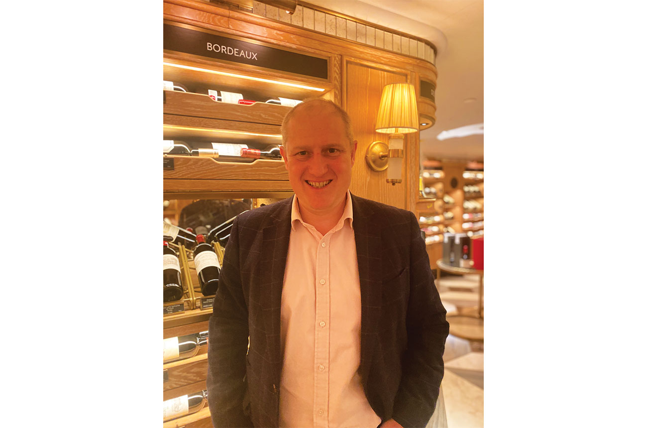 Adam Porter with wine on shelves in background