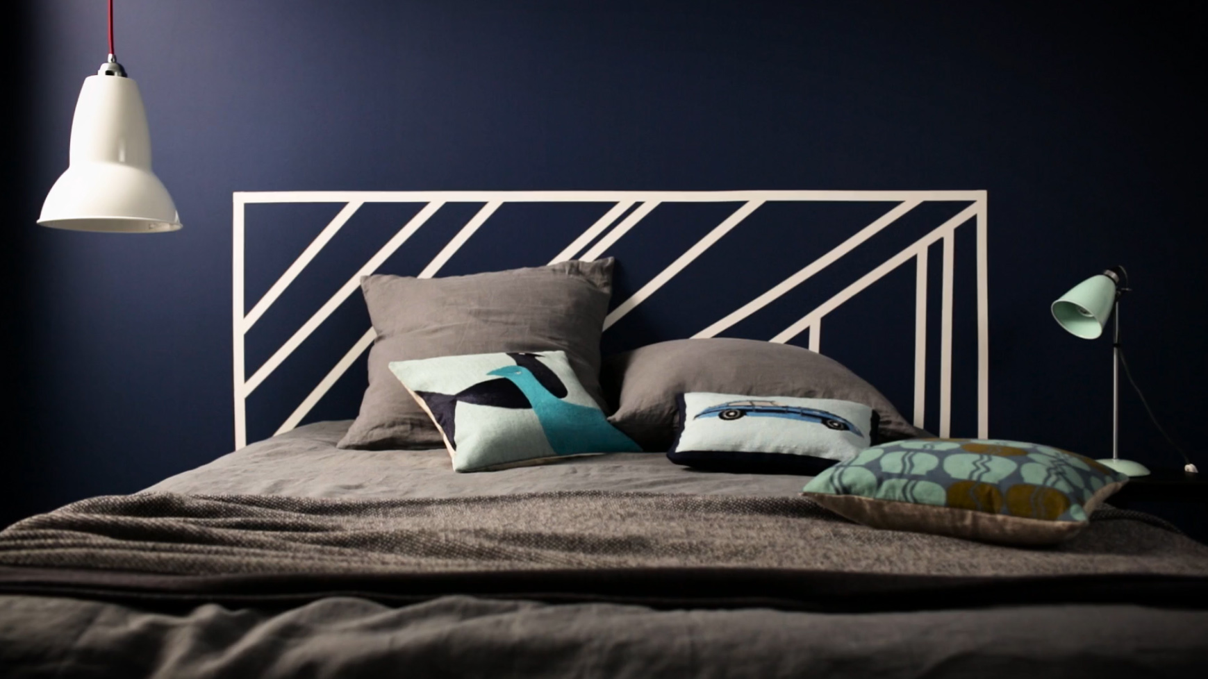 white painted headboard on a dark blue wall