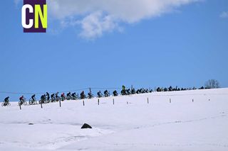 The peloton rides through the snow at the Tour de Romandie. 