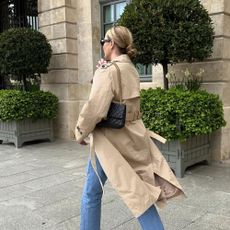 A woman in jeans and a trench coat