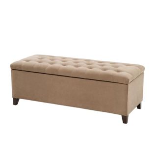 A light brown tufted button rectangular storage ottoman tilted at an angle to the right