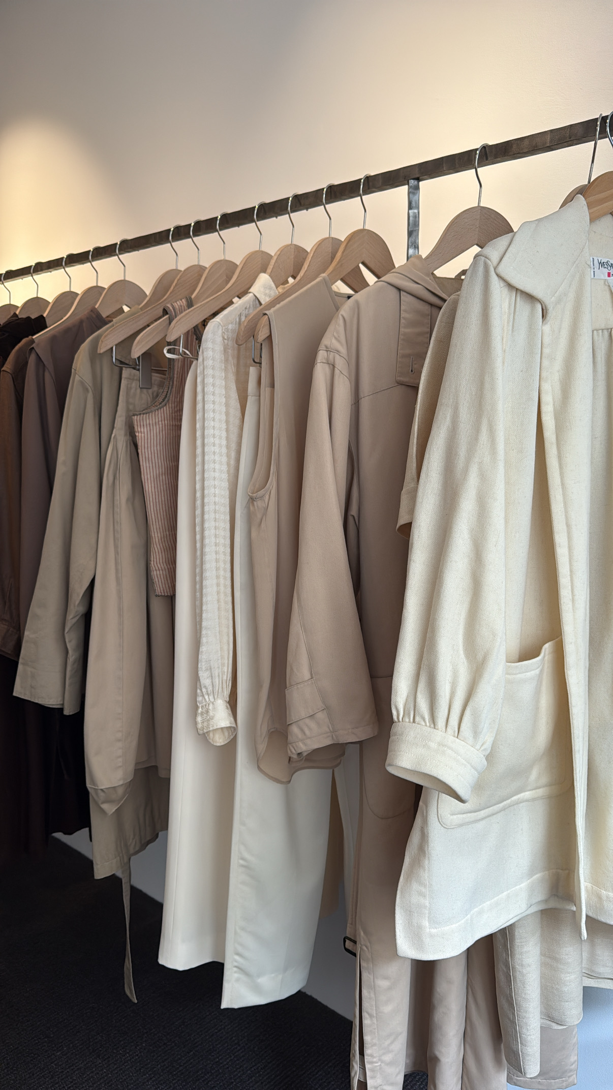 Rack of white and tan clothing inside Preclothed, one of the best vintage stores in Paris.