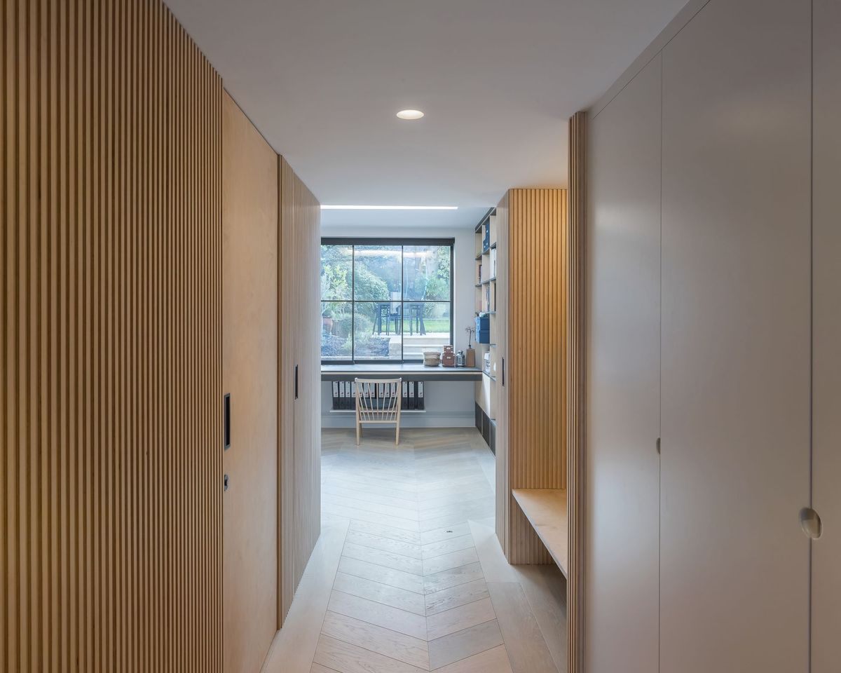 A modern hallway with fire door hidden in a wood clad recess