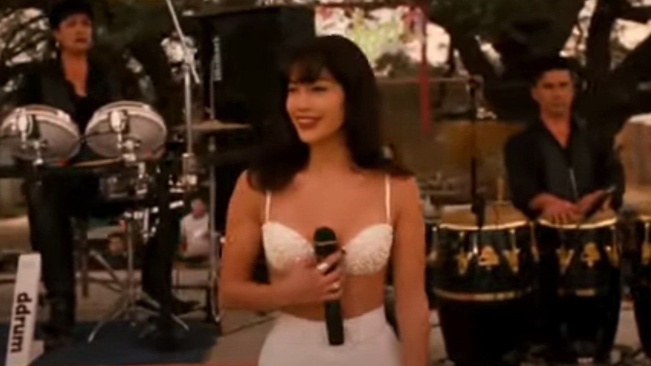 Jennifer Lopez como Selena sosteniendo un micrófono en la película Selena