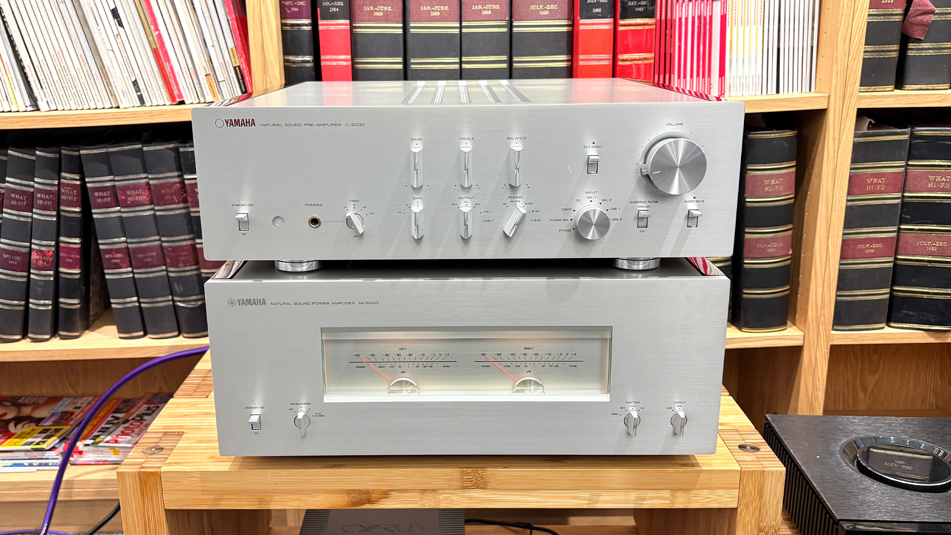 Yamaha C-5000/M-5000 pre/power amplifier on wooden hi-fi rack in front of bookcase