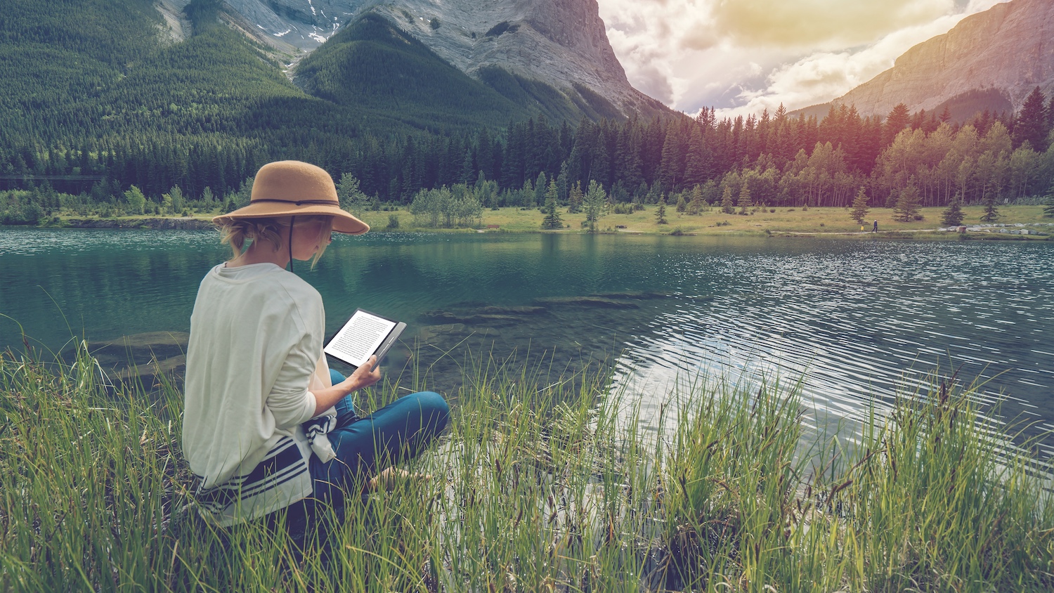 How to relax on Mother's Day: a woman reads on a Kobo ereader beside the lake