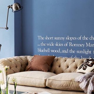 blue wall with lamp and sofa with cushions