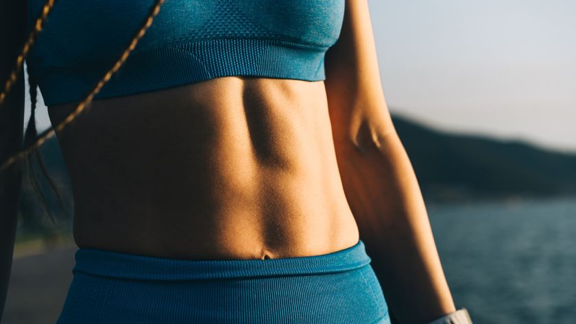 Woman&#039;s abs pictured close up in blue activewear