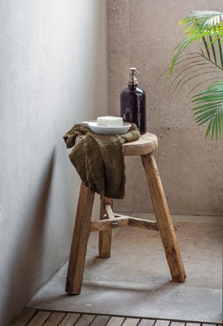 three legged wood stool in a shower room