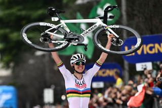 World Champion Tadej Pogacar raises his bicycle after crossing the finish line to win the 118th edition of the Giro di Lombardia (Tour of Lombardy) 2024