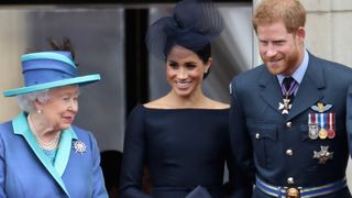 Queen Elizabeth II, Meghan, Duchess of Sussex, Prince Harry, Duke of Sussex watch the RAF flypast on the balcony of Buckingham Palace