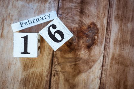 the words February 16 on a wooden background