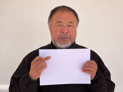 Ai Weiwei holds blank sheet of paper ahead of art performance at London’s Hyde Park on Saturday 10 December