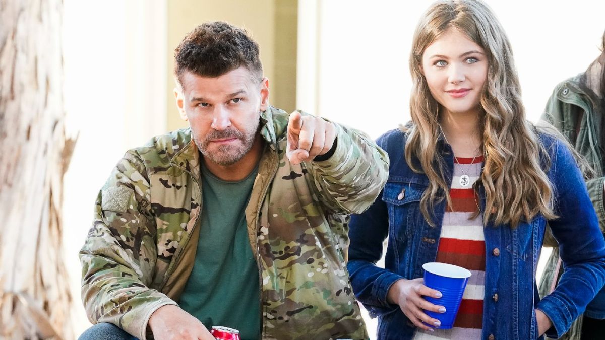 David Boreanaz as Jason Hayes and Kerri Medders as Emma Hayes standing next to each other and holding drinks on SEAL Team.